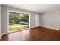 Sun-filled living room with hardwood floors and a large window overlooking the yard at 765 Shellnut Dr, Forest Park, GA 30297