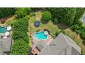 Aerial view of a private backyard oasis with a sparkling pool, spa, and lush landscaping at 100 Braxton Way, Roswell, GA 30075