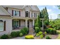 Charming home with a covered porch, brickwork, decorative shutters, and well-maintained landscaping at 100 Braxton Way, Roswell, GA 30075