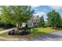 Attractive two-story home boasting a lush green lawn, mature trees, and a well-manicured landscape at 100 Braxton Way, Roswell, GA 30075