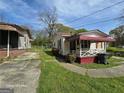 Exterior shot of home featuring a red and white color scheme, concrete driveway, and small front yard at 1243 Hill Nw St, Conyers, GA 30012
