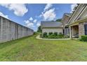 Large backyard with lush green grass, a stone privacy wall, and manicured landscaping surrounding the home at 1815 Sharon Rd, Cumming, GA 30041