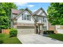 Beautiful two-story home featuring a stone facade, two-car garage, and well-maintained landscaping at 1326 Castleberry Dr, Buford, GA 30518