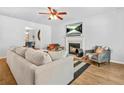 Cozy living room features a fireplace with a TV, ceiling fan, and plush seating at 1326 Castleberry Dr, Buford, GA 30518