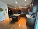 Spacious kitchen with dark wood cabinets, granite countertops, and stainless steel appliances at 4305 Evans Farms Dr, Cumming, GA 30040