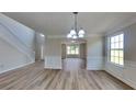 Bright living room with wood flooring, decorative trim, and large windows offering plenty of natural light at 5052 Hickory Cir, Ellenwood, GA 30294