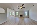 Spacious living room with a fireplace, vaulted ceiling, fan, and natural light from large windows at 5052 Hickory Cir, Ellenwood, GA 30294