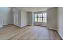 Inviting living room featuring wood flooring, a large window, and neutral paint, creating a cozy atmosphere at 5052 Hickory Cir, Ellenwood, GA 30294