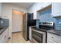 Efficient kitchen with stainless steel appliances, white cabinetry and blue backsplash at 1074 Peachtree Ne Walk # B404, Atlanta, GA 30309