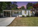 Charming brick home with a well-manicured lawn, a covered driveway and a quaint front garden at dusk at 962 Cardova Ne Dr, Atlanta, GA 30324