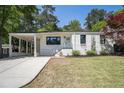 Charming home featuring a well-manicured lawn, covered car port, and freshly painted exterior at 962 Cardova Ne Dr, Atlanta, GA 30324