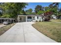 View of the home's exterior with lush lawn, long driveway, and convenient covered parking at 962 Cardova Ne Dr, Atlanta, GA 30324