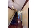 Inviting hallway with hardwood floors, staircase, and vintage pendant lighting fixture at 260 Manning Sw Rd # 42, Marietta, GA 30064
