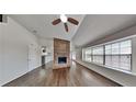 Bright living room featuring hardwood floors, brick fireplace, and large windows for ample natural light at 516 N Shore Rd, Lithonia, GA 30058