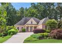 Beautiful brick home with lush landscaping, mature trees, and a long driveway, set on a well-manicured lawn at 980 Ector Chase Nw, Kennesaw, GA 30152