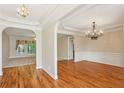 Open-concept living and dining areas featuring hardwood floors, elegant chandeliers, and abundant natural light at 980 Ector Chase Nw, Kennesaw, GA 30152