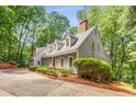 Inviting gray home with a well-manicured lawn, red front door, and a long driveway at 130 River Ne Lndg, Sandy Springs, GA 30350