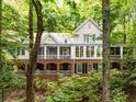 Charming two-story home with brick and light gray exterior, surrounded by lush green trees at 130 River Ne Lndg, Sandy Springs, GA 30350