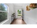 Bright foyer featuring hardwood floors, white wainscoting, and natural light streaming through a window at 4591 Grenadine Cir, Acworth, GA 30101