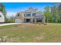 New construction home with lush green lawn, brick and gray siding, and architectural details, and an attached garage at 4708 Cooling Water Sw Cir, Powder Springs, GA 30127