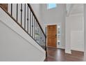 Open foyer with hardwood floors, two story ceiling, and a staircase with black iron railings at 4708 Cooling Water Sw Cir, Powder Springs, GA 30127