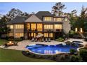 Resort-style backyard with a luxurious pool, cozy fire pit, and multiple seating areas for outdoor entertainment at 670 Trinity Pl, Suwanee, GA 30024