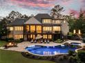 Luxurious backyard with a sparkling pool, spa, fire pit, and outdoor lounge area, perfect for entertaining at 670 Trinity Pl, Suwanee, GA 30024