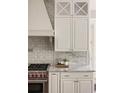 Close-up showcasing the kitchen's sleek countertops, stainless steel appliances, and elegant tile backsplash at 670 Trinity Pl, Suwanee, GA 30024