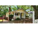 Quaint yellow home showcasing a covered porch, brick chimney, and inviting curb appeal at 1162 Sims St, Atlanta, GA 30310