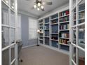 Well-lit home office with built-in bookshelves, french doors, and a neutral color palette at 1535 Justine Se Way, Mableton, GA 30126
