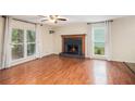 Bright and spacious living room featuring a brick fireplace, ceiling fan, and large windows at 115 Jamie Dr, Hiram, GA 30141