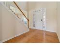 Bright foyer featuring hardwood flooring, a staircase, and a front door with decorative sidelights at 7325 Thoreau Cir, Atlanta, GA 30349