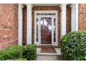 Welcoming front entrance featuring decorative sidelights, white columns and beautiful landscaping at 7325 Thoreau Cir, Atlanta, GA 30349