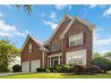 Beautiful two-story home featuring a brick facade, manicured lawn, attached two car garage and inviting curb appeal at 7325 Thoreau Cir, Atlanta, GA 30349