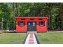 A charming red shed featuring black shutters and brick walkway at 1424 Brighton, Loganville, GA 30052