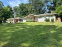 Suburban home with a lush green lawn and mature trees at 1909 Cindy Dr, Decatur, GA 30032