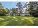 Inviting home with a lush green lawn, mature trees, and a freshly painted exterior at 1909 Cindy Dr, Decatur, GA 30032