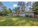 Inviting home with a lush green lawn, mature trees, and a freshly painted exterior at 1909 Cindy Dr, Decatur, GA 30032