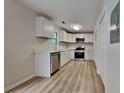 Bright, updated kitchen with white cabinetry, stainless steel appliances, and laminate floors at 5634 Windwood Rd, Atlanta, GA 30349