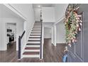 Bright foyer with hardwood floors, staircase, and a decorative floral wreath on the front door at 2586 Abbotts Glen Nw Dr, Acworth, GA 30101