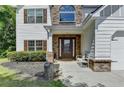 Inviting home entrance with a cozy bench, brick accents, and meticulous landscaping at 2020 Walking Horse Trl, Cumming, GA 30041