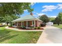 Quaint brick home featuring a covered porch with a swing and a lengthy driveway leading to a garage at 2620 Dr Bramblett Rd, Cumming, GA 30028