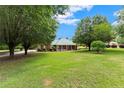 Expansive front yard showcasing a well-maintained lawn and mature trees surrounding a charming home at 2620 Dr Bramblett Rd, Cumming, GA 30028
