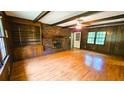 Spacious living room featuring wood paneling, a brick fireplace, and hardwood floors at 1110 Blackwell Rd, Marietta, GA 30066