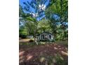 View of the home's exterior, showing the yard and surrounding mature trees at 2700 Snapfinger Rd, Decatur, GA 30034