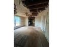 Living room with exposed ceiling, dated carpet, and an opening leading into the kitchen at 2700 Snapfinger Rd, Decatur, GA 30034