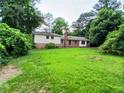 View of the home's backyard, featuring lush greenery and partial shade at 3026 Hidden Forest Dr, Snellville, GA 30078