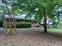 Traditional home with a manicured front yard and mature shade tree at 3026 Hidden Forest Dr, Snellville, GA 30078