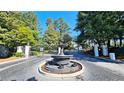 Gated entrance to the community with a beautiful water fountain and lush landscaping at 3304 Pine Heights Ne Dr, Atlanta, GA 30324