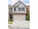Inviting townhome with a two-car garage, stone detailing, and lush greenery at 2243 Knoxhill Se Vw, Smyrna, GA 30082
